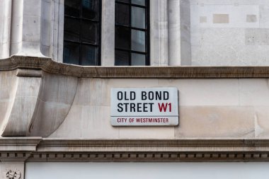 Londra, İngiltere - 27 Ağustos 2023: West End 'deki eski Bond Caddesi tabelası. Şirket, prestijli ve pahalı dükkanlarla Avrupa 'nın en pahalı ve aranan bölgelerinden biri haline geldi.