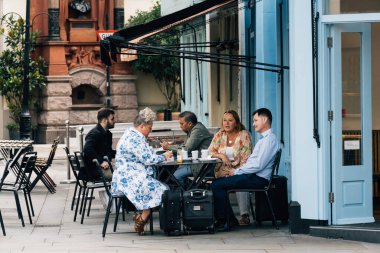 Londra, İngiltere - 25 Ağustos 2023: Bilinmeyen insanlar Covent Garden yakınlarındaki bir kafenin terasında oturarak kahvaltıdan keyif alıyorlar.