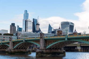 LONDON, İngiltere - 26 Ağustos 2023: Southwark Köprüsü Thames Nehri üzerinde Londra şehrindeki gökdelenlere karşı. Alacakaranlıkta görüntüle