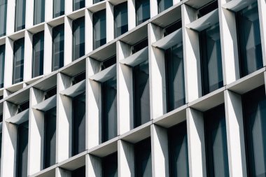 Londra, İngiltere - 25 Ağustos 2023: Londra 'daki modern ofis binası. Düşük açı beyaz bulutlu mavi gökyüzüne karşı.