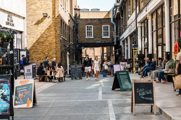 Londra, İngiltere - 25 Ağustos 2023: Dray Walk 'da insanların alışveriş yaptığı sokak sahnesi, Shoreditch Bölgesi' nde Brick Lane yakınlarında bir yaya sokağı.