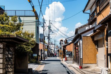 Nara, Japonya - 14 Ağustos 2024: Japonya 'nın Nara kentinde aile evleri ve yerel dükkanlarla dolu geleneksel dar bir cadde. Sahne, yukarıdaki elektrik kablolarıyla mahallenin günlük yaşamını yakalıyor ve bu kentsel arazinin cazibesini arttırıyor.