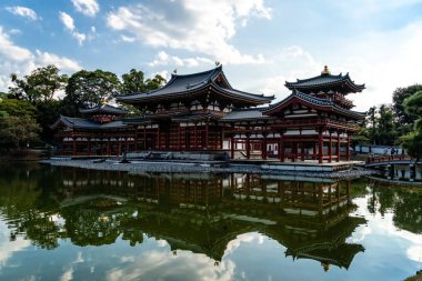 Uji, Japonya - 14 Ağustos 2024: Byodoin Tapınağı Phoenix Hall ve çarpıcı yansıma gölüyle ünlü ünlü bir Budist tapınağıdır. Bir UNESCO Dünya Mirası sahası