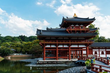 Uji, Japonya - 14 Ağustos 2024: Byodoin Tapınağı Phoenix Hall ve çarpıcı yansıma gölüyle ünlü ünlü bir Budist tapınağıdır. Bir UNESCO Dünya Mirası sahası