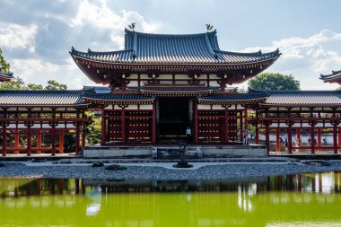 Uji, Japonya - 14 Ağustos 2024: Byodoin Tapınağı Phoenix Hall ve çarpıcı yansıma gölüyle ünlü ünlü bir Budist tapınağıdır. Bir UNESCO Dünya Mirası sahası