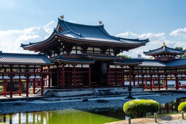 Uji, Japonya - 14 Ağustos 2024: Byodoin Tapınağı Phoenix Hall ve çarpıcı yansıma gölüyle ünlü ünlü bir Budist tapınağıdır. Bir UNESCO Dünya Mirası sahası