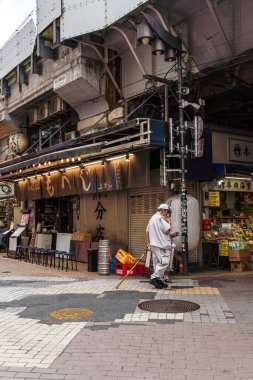 Tokyo, Japonya - 6 Ağustos 2024: Ueno, Tokyo 'da canlı bir sokak pazarı olan Ameyoko, hareketli dükkanlar, gıda tezgahları ve yerel ürünler sunarak Japon sokak ticaretinin canlı özünü yakalıyor.