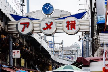 Tokyo, Japonya - 6 Ağustos 2024: Ueno, Tokyo 'da canlı bir sokak pazarı olan Ameyoko, hareketli dükkanlar, gıda tezgahları ve yerel ürünler sunarak Japon sokak ticaretinin canlı özünü yakalıyor.