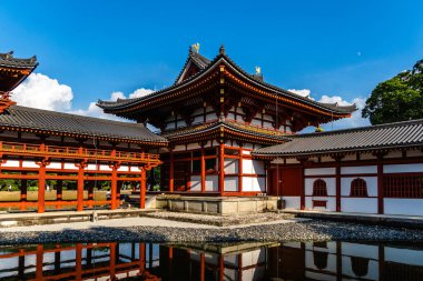 Uji, Japonya - 14 Ağustos 2024: Byodoin Tapınağı Phoenix Hall ve çarpıcı yansıma gölüyle ünlü ünlü bir Budist tapınağıdır. Bir UNESCO Dünya Mirası sahası