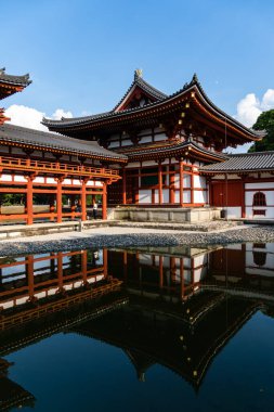 Uji, Japonya - 14 Ağustos 2024: Byodoin Tapınağı Phoenix Hall ve çarpıcı yansıma gölüyle ünlü ünlü bir Budist tapınağıdır. Bir UNESCO Dünya Mirası sahası