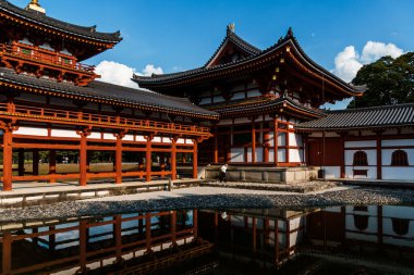 Uji, Japonya - 14 Ağustos 2024: Byodoin Tapınağı Phoenix Hall ve çarpıcı yansıma gölüyle ünlü ünlü bir Budist tapınağıdır. Bir UNESCO Dünya Mirası sahası