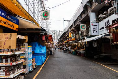 Tokyo, Japonya - 6 Ağustos 2024: Ueno, Tokyo 'da canlı bir sokak pazarı olan Ameyoko, hareketli dükkanlar, gıda tezgahları ve yerel ürünler sunarak Japon sokak ticaretinin canlı özünü yakalıyor.