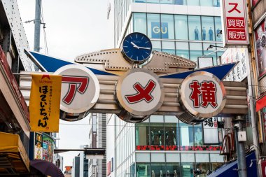 Tokyo, Japonya - 6 Ağustos 2024: Ueno, Tokyo 'da canlı bir sokak pazarı olan Ameyoko, hareketli dükkanlar, gıda tezgahları ve yerel ürünler sunarak Japon sokak ticaretinin canlı özünü yakalıyor.