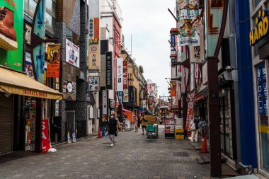 Tokyo, Japonya - 6 Ağustos 2024: Ueno, Tokyo 'da canlı bir sokak pazarı olan Ameyoko, hareketli dükkanlar, gıda tezgahları ve yerel ürünler sunarak Japon sokak ticaretinin canlı özünü yakalıyor.