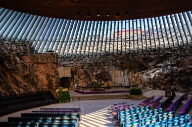 Helsinki, Finlandiya - 19 Ağustos 2024: Temppeliaukio Kilisesi. Sahadaki bankların iç görünümü