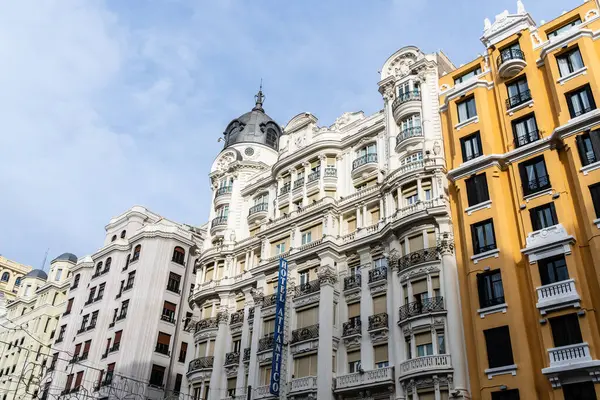 Madrid, İspanya - 16 Kasım 2024: Madrid 'in sinema ve mağazalarıyla ünlü ikonik caddesi Gran Via' daki tarihi konut binaları.
