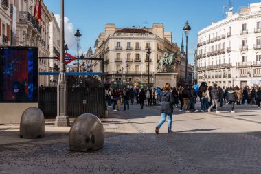 Madrid, Spain - 2025-02-22: A sunny day in Puerta del Sol, bustling with people and framed by classic buildings, creating a vibrant urban scene. clipart