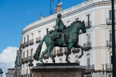 Madrid, İspanya - 2025-02-22: Parlak bir günde Kral III. Charles 'ın Puerta del Sol' daki binicilik heykelinin manzarası. Arkaplanda mimari bulanık.