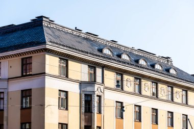 Helsinki, Finlandiya 'da bir apartman cephesinin mimari ayrıntıları, metal bir çatı, kemerli yatakhane pencereleri ve dekoratif ayrıntılar.