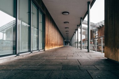 Oslo, Norveç - 10 Ağustos 2019: Astrup Fearnley Müzesi. Norveç 'in Oslo kentinde bulutlu bir günde Oslofjord' a bakan sütunlarla kaplı bir yürüyüş yolunun perspektifli çekimi.