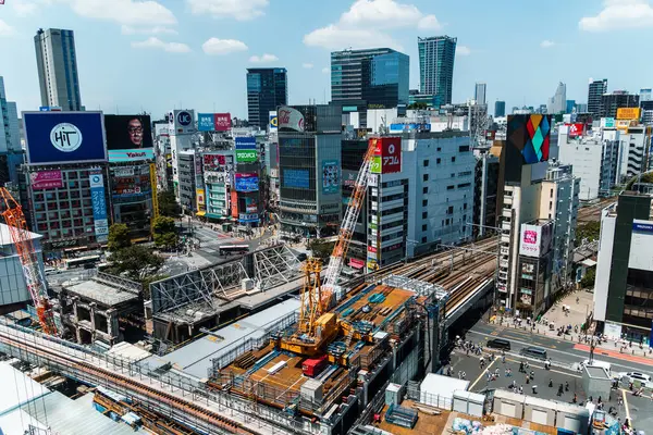 Tokyo, Japonya - 4 Ağustos 2024: Tokyo, Japonya 'da Shibuya bölgesinin hareketli havadan görünüşü, ikonik şehir manzarasının ortasındaki bir inşaat alanını gösteriyor.