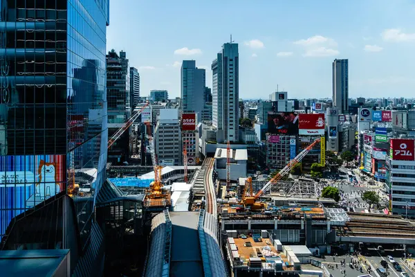 Tokyo, Japonya - 4 Ağustos 2024: Modern binaların, inşaatın ve Tokyo, Japonya 'nın hareketli enerjisinin sergilendiği dinamik bir manzara.