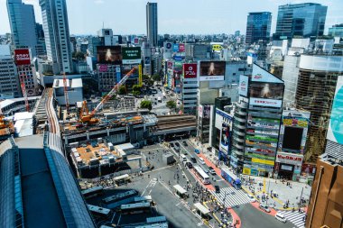 Tokyo, Japonya - 4 Ağustos 2024: Gündüz hava görüntüsü Shibuya, Tokyo 'nun hareketli kentsel manzarasını yakalar, hareketli caddelerini ve yüksek binalarını gözler önüne serer.