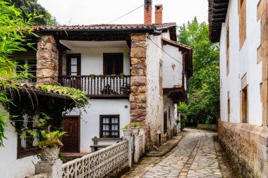 Büyüleyici kır evleri İspanya 'nın kuzeyinde Cantabria' nın pitoresk Saja Nehri Vadisi 'nde dar bir kaldırım taşı caddesi hizasında..