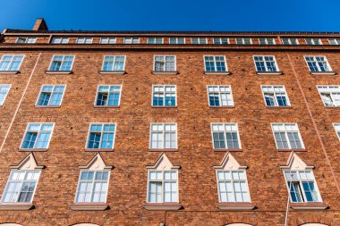 Yukarıdan bakıldığında, Finlandiya 'nın Helsinki şehrinde açık mavi gökyüzünün altında bulunan kırmızı tuğlalı bir apartmanın ayrıntılarını görebilirsiniz..