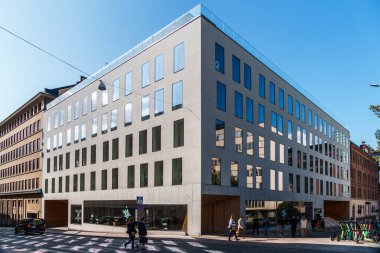 Helsinki, Finlandiya - 19 Ağustos 2024: Helsinki 'de güneşli bir günde sayısız penceresi bulunan gösterişli, açık renkli bir binanın modern mimarisi.