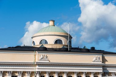 Helsinki, Finlandiya - 19 Ağustos 2024: Finlandiya Ulusal Kütüphanesi. Helsinki 'deki klasik bir binanın kubbesinin detaylı bir görüntüsü, kabarık beyaz bulutlu parlak mavi bir gökyüzüne karşı kurulmuş..