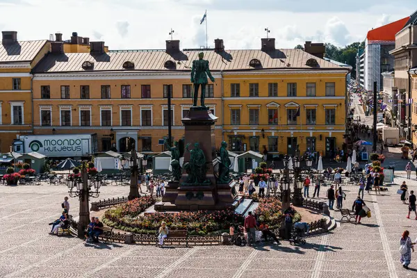 Helsinki, Finlandiya - 19 Ağustos 2024: Helsinki, Finlandiya 'da güneşli bir yaz gününde toplanan ve eğlenen insanların olduğu Esplanadi Parkı. Işık bulutlarıyla güneşli bir gün.