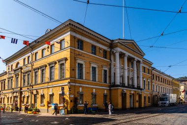 Helsinki, Finlandiya - 19 Ağustos 2024: Sarı Senato binası Fin mimarisini ve mirasını temsil eden güneşli bir günde belirgin bir şekilde ayakta duruyor.