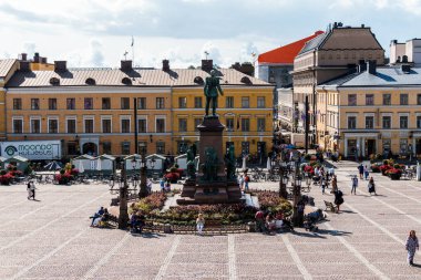 Helsinki, Finlandiya - 19 Ağustos 2024: Helsinki, Finlandiya 'da güneşli bir yaz gününde toplanan ve eğlenen insanların olduğu Esplanadi Parkı. Işık bulutlarıyla güneşli bir gün.