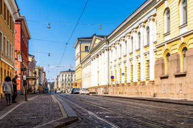 Helsinki, Finlandiya - 19 Ağustos 2024: Helsinki 'deki pitoresk bir sokak manzarası güneşli bir günde şehrin mimarisinin ve günlük yaşamının cazibesini yakalar.
