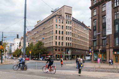 Helsinki, Finlandiya - 19 Ağustos 2024: Helsinki, Finlandiya 'da hareketli bir cadde, bulutlu bir günde şehrin modern yaşam ve geleneksel mimarinin karışımını sergiler..