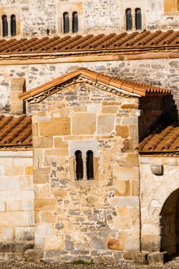 Küçük, kemerli bir penceresi ve terakotta çatı fayansları olan antik taş kilise. San Salvador de Valithos Villaviciosa 'da.