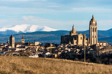 Arka planda Guadarrama sıradağları olan Segovia, İspanya 'nın panoramik manzarası, tarih ve doğal güzelliğin bir karışımını sunuyor..