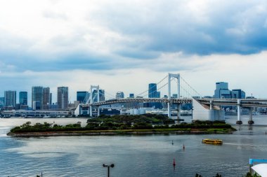 Tokyo, Japonya 'daki Gökkuşağı Köprüsü' nün manzarası Odaiba 'yı anakaraya bağlıyor ve arka planda gökyüzü görünüyor..