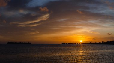 Tahiti tatil köyü su üstü kulübeleri, villalar ve bungalov, Fransız Polinezyası 'nda gün batımı.