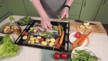 Levrek balığını ızgarada pişirmek için ahşap tahta üzerinde aromatik otlar ve sebzelerle hazırlıyorum.