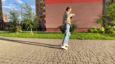 Canlı ve hareketli şehir ortamında şık ve büyüleyici bir dans figürü sergileyen bekar bir kadın.