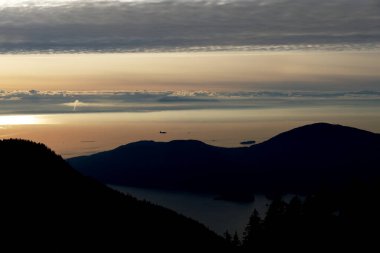 Gün batımında Britanya Kolombiyasında deniz manzaralı dağlar