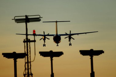 Plane landing at the airport runway with the navigation lights - sunset clipart