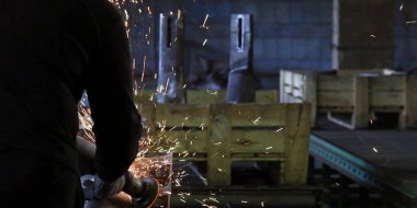 Kıvılcımlar, fabrikada metal işlemek için makinenin başına geçer.