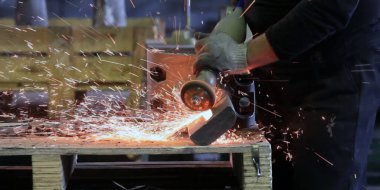 Kıvılcımlar, fabrikada metal işlemek için makinenin başına geçer.