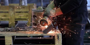 Kıvılcımlar, fabrikada metal işlemek için makinenin başına geçer.