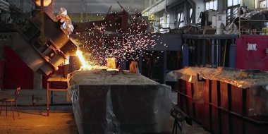 Metalurji fabrikasında ya da fabrikada patlayıcı fırınında metal döküm işlemi. Sıvı demir erimiş metal kabın içine dökülüyor, ağır endüstri arka planı