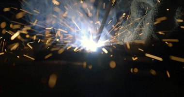 Metal yapıların kıvılcım ve dumanla kaynaştırılması, yakın plan.