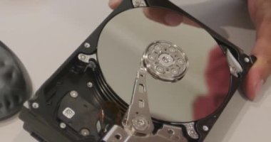 Bir adamın elinde tornavida olan bir sabit disk.